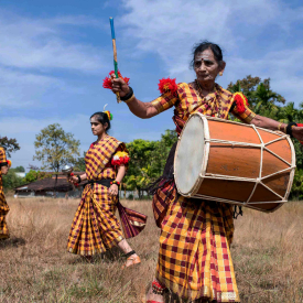 Choodamani demonstrates the different notes the Dollu emanates; the right side of the drum is struck with a cane and produces a higher note, whereas the left side of the drum is struck with fingers, producing a lower and heavier sound. 