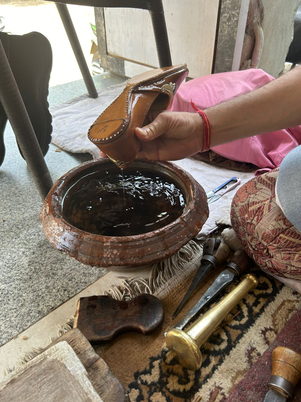 The process of reshaping a worn jutti begins by soaking it in water, allowing the leather to soften and become pliable. (Picture Credits: Nandini Agarwal)