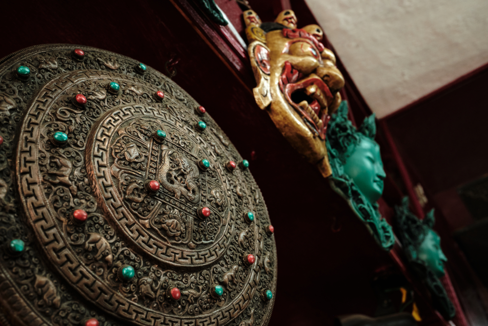 'Dhaal' or shield adorned with repoussé dragons and geometric borders with turquoise and coral inlays.