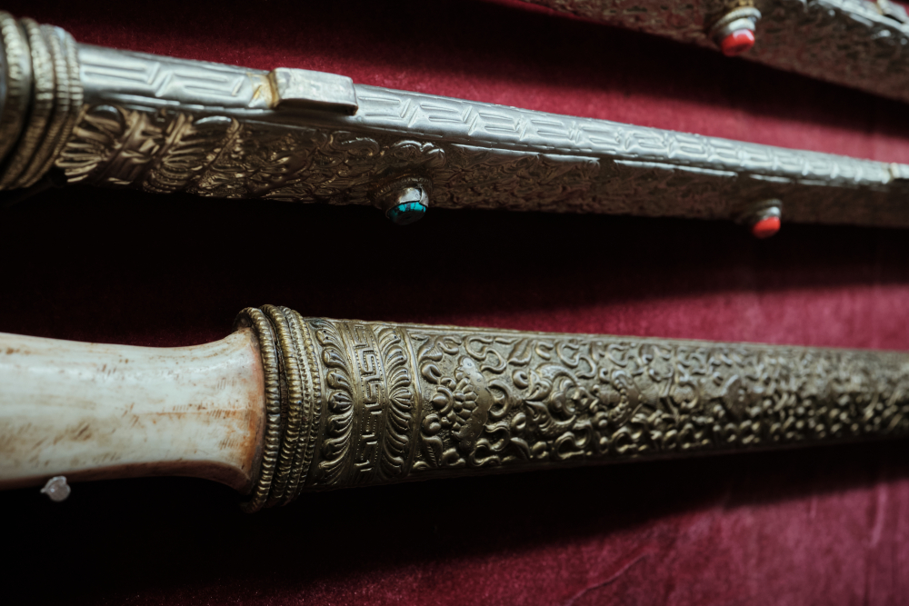 Sword with brass and metal sheath with geometric and floral repoussé and turquoise and coral inlays.