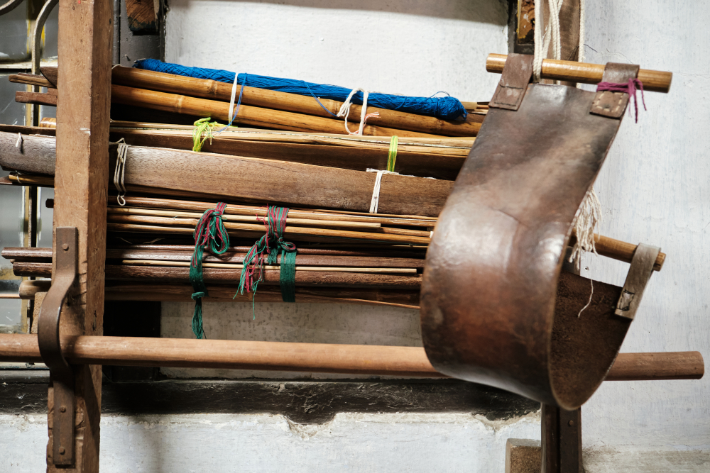 The weaving setup with stacked wooden and bamboo slats and a leather back strap at DHH. (Picture Credits: Abhishek Anil.)