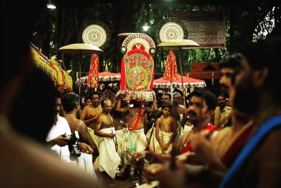 Fig 2. Ceremonial procession at Vetticode temple during Ayilyam festival. The idol of Nagaraja is decorated with flowers and silk, and the chief priest carries the idol from temple to Meppallil Illam. The procession is accompanied by the beats of musical instruments, decorated umbrellas, women carrying lamps, and people chanting mantras. It is believed that one who is blessed by the sight of this procession will be protected from animal poison the coming year