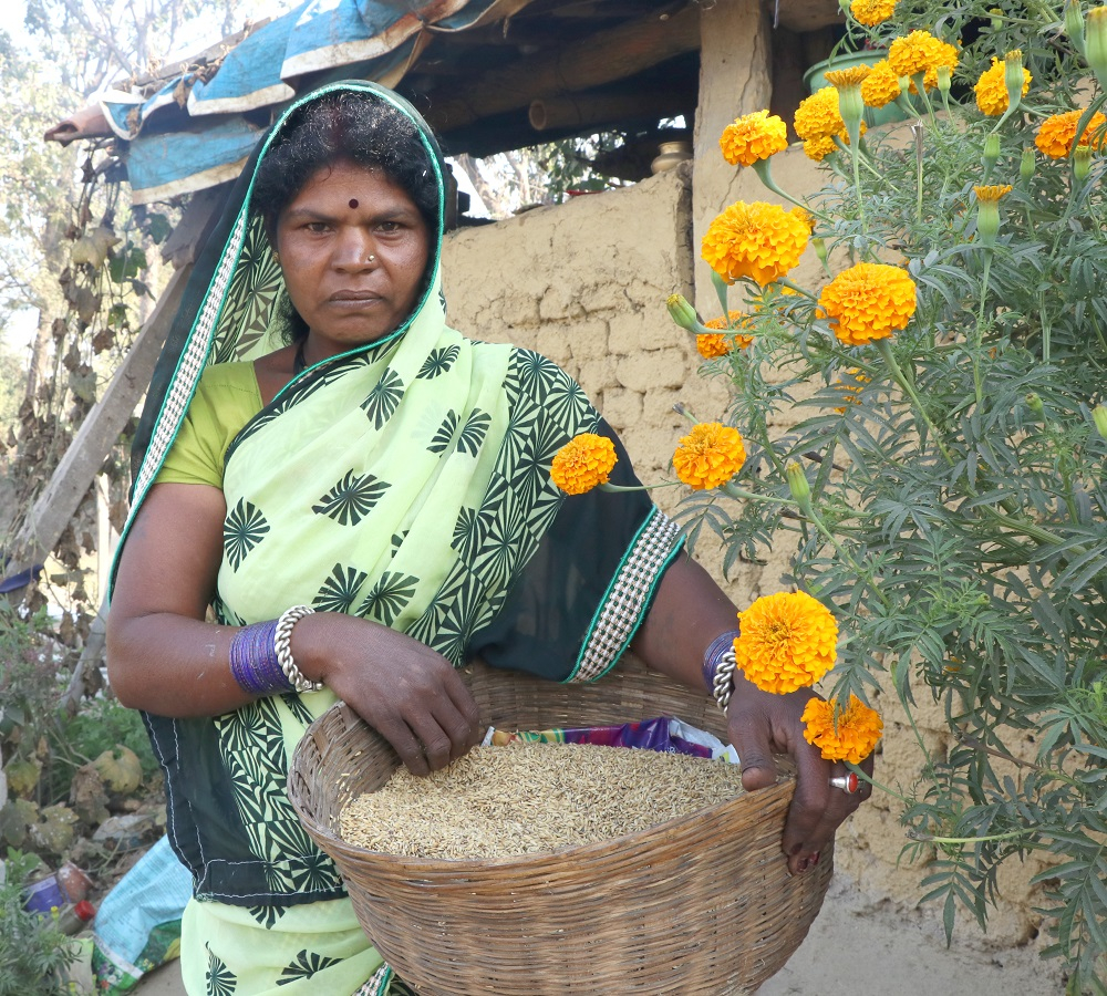 Woman holding a grain basket to be distributed amongst the children