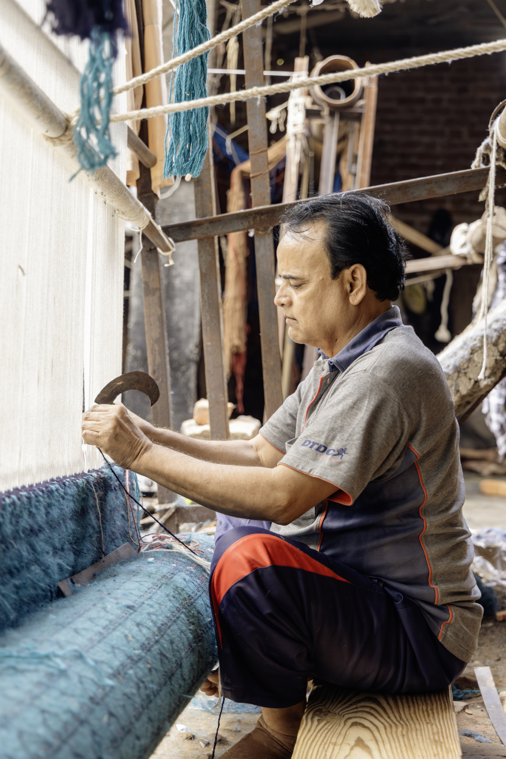 Carpet master weaver, also the owner of Amma Carpets, at work on a loom in his workshop. (Picture Credits: Pranjal Jain)