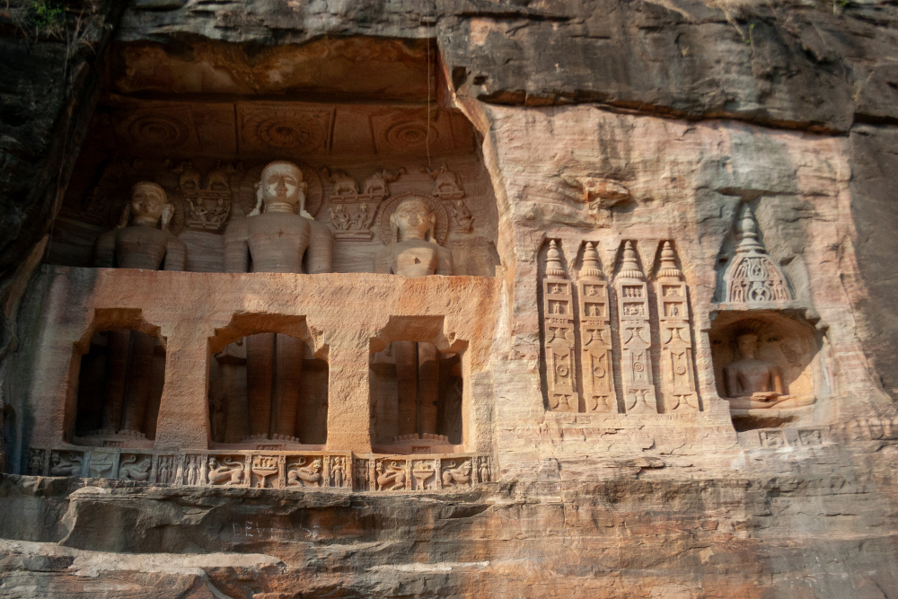 Rock-cut Jain Tirthankara sculptures carved into sandstone cliffs at Gwalior Fort, overlooking the fort plateau on the western escarpment. (Picture Credits: Ayan Ghosh)
