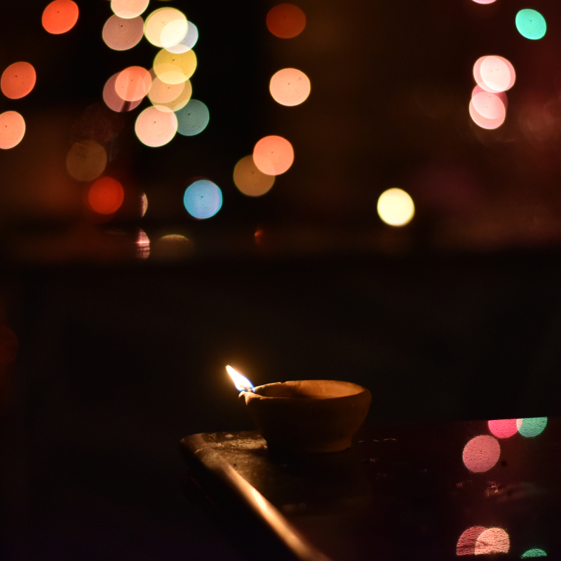 Diwali decorations are mainly done with diyas and lights. In the picture, we can see a lighted diya with fairy lights in the background (Courtesy: Madhurjya Borah)