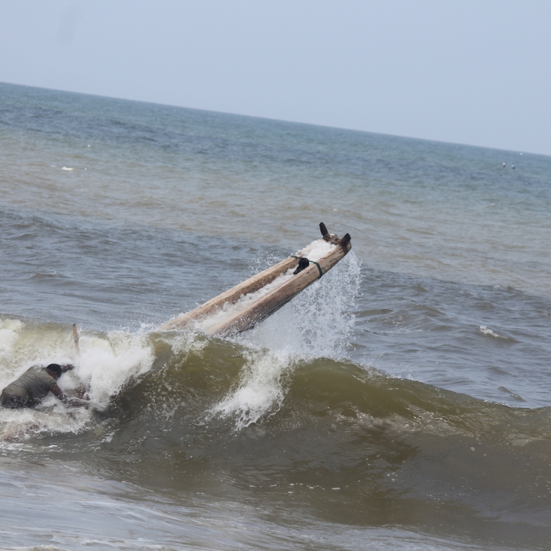 Fisherman trying to launch his kattamaram in the rough sea