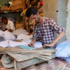 Attaching bamboo sticks along the kite edges to prevent tearing and add stiffness (Courtesy: Ashna Patel)