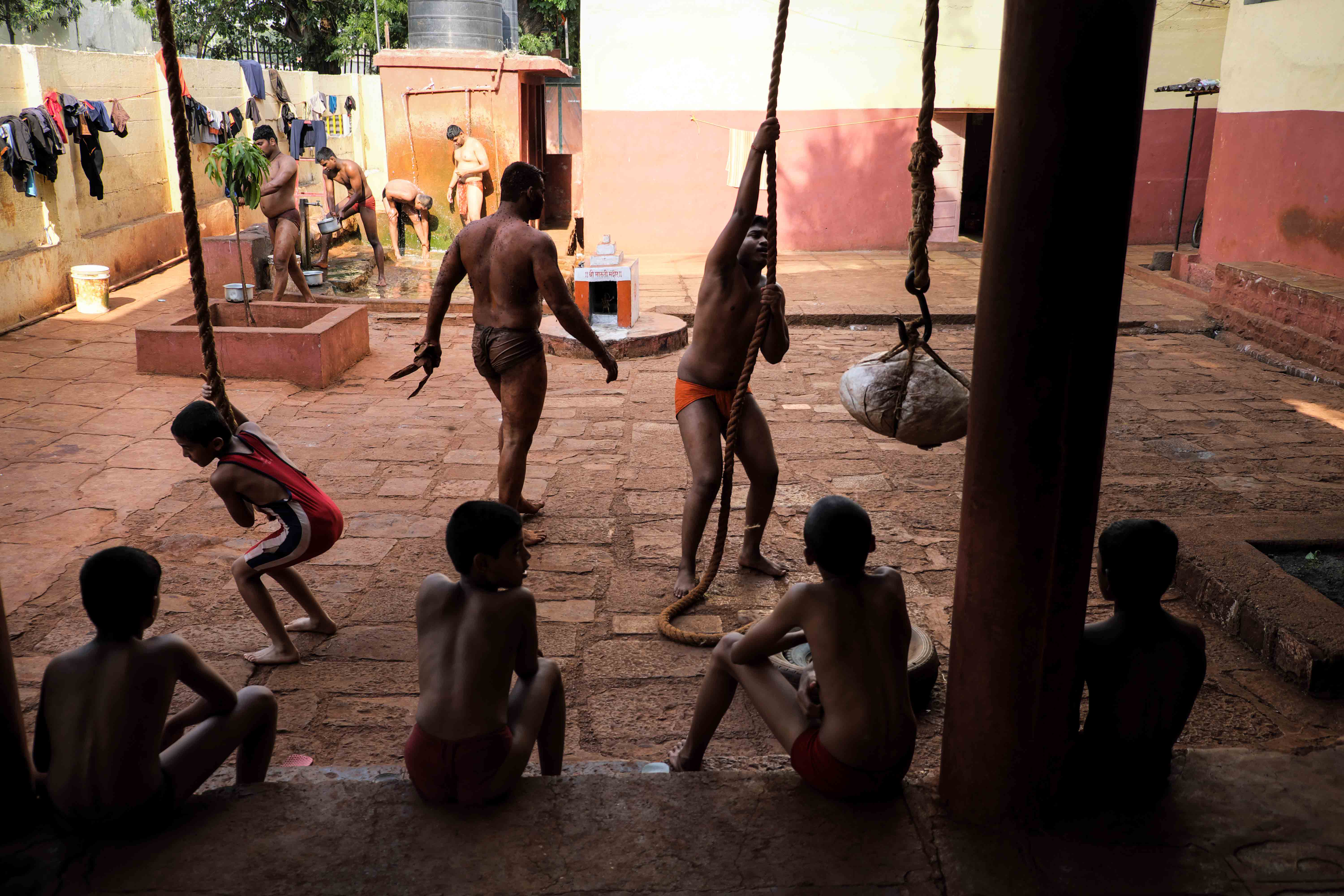  Scene outside Shahupuri Akhara where wrestlers are practising rope climbing. Rope climbing is a tremendous exercise for strengthening biceps, arms and upper body and particularly effective in developing strong grip, which is a much needed skill while grappling wrestlers who have sweaty oil-smeared bodies. Photograph by Indrajit Khambe ©Sahapedia 