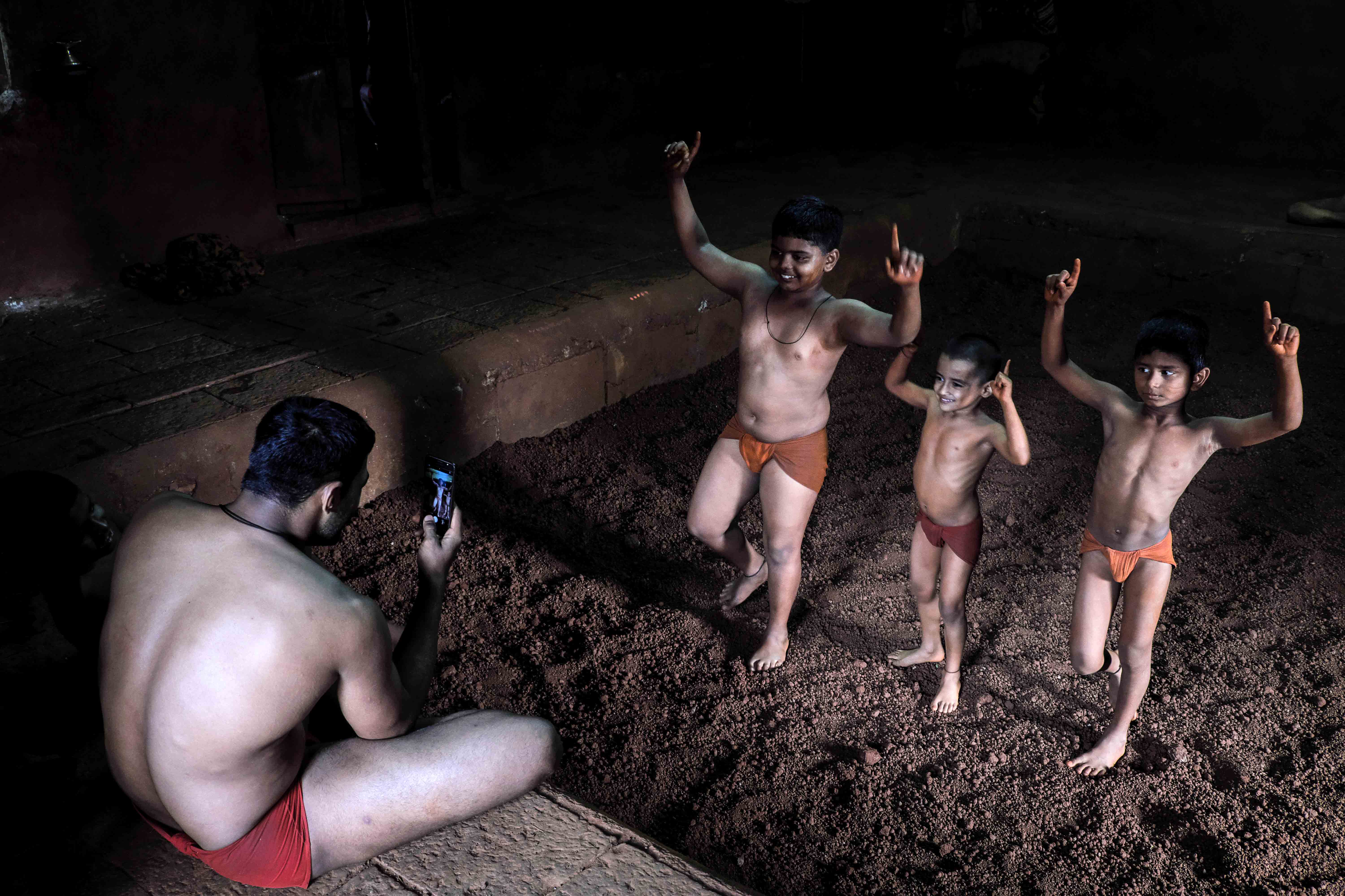 Wrestlers posing for a group photo at Gangavesh Taleem (akhara), Kolhapur. This is the usual pose they do after winning a bout. Photograph by Indrajit Khambe ©Sahapedia 