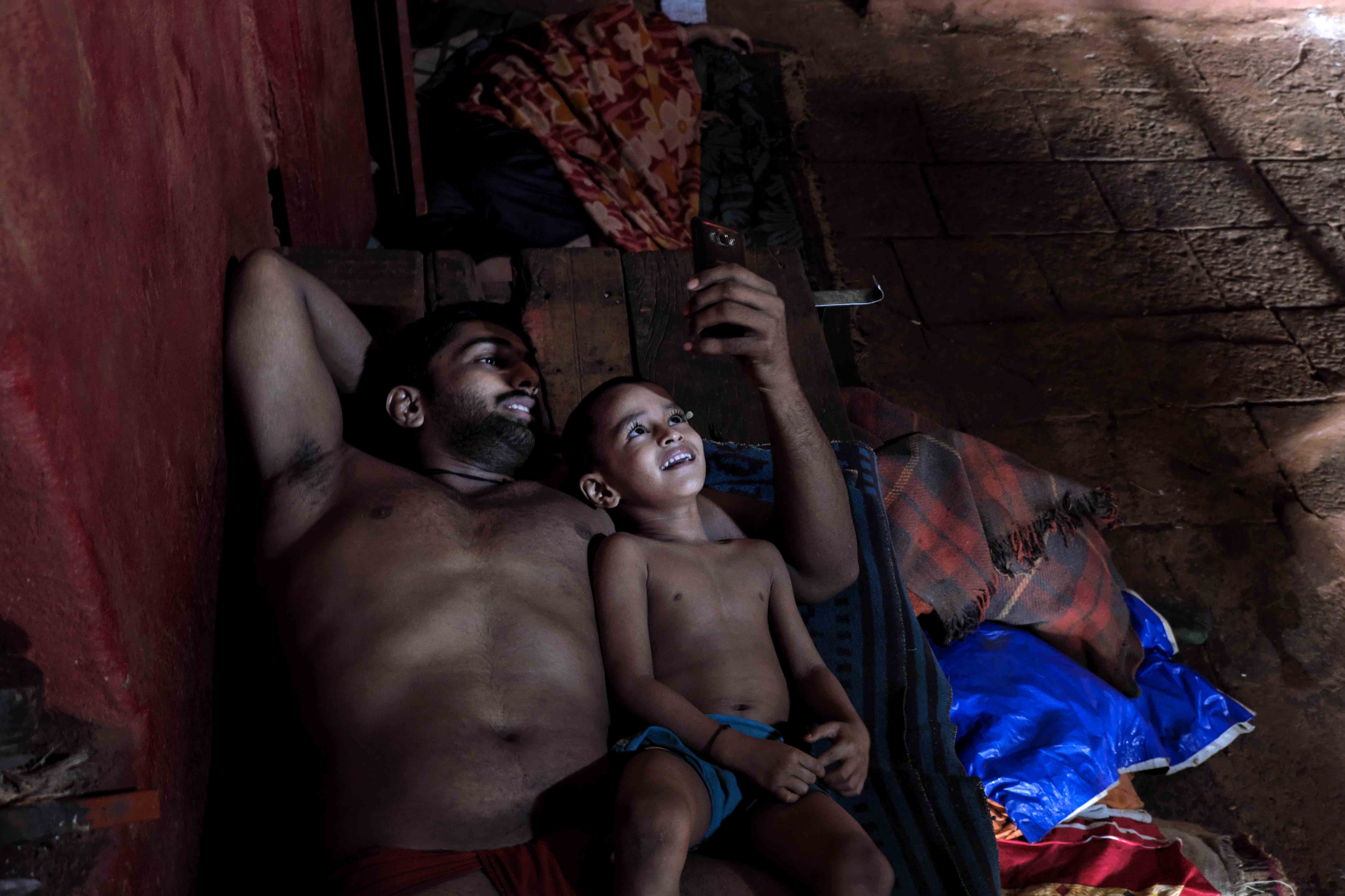 A senior pehelwan spending time with a young trainee at Gangavesh Akhara, Kolhapur. The akharas function like dormitories where wrestlers from various age groups live together for long durations, away from their families. Photograph by Indrajit Khambe ©Sahapedia