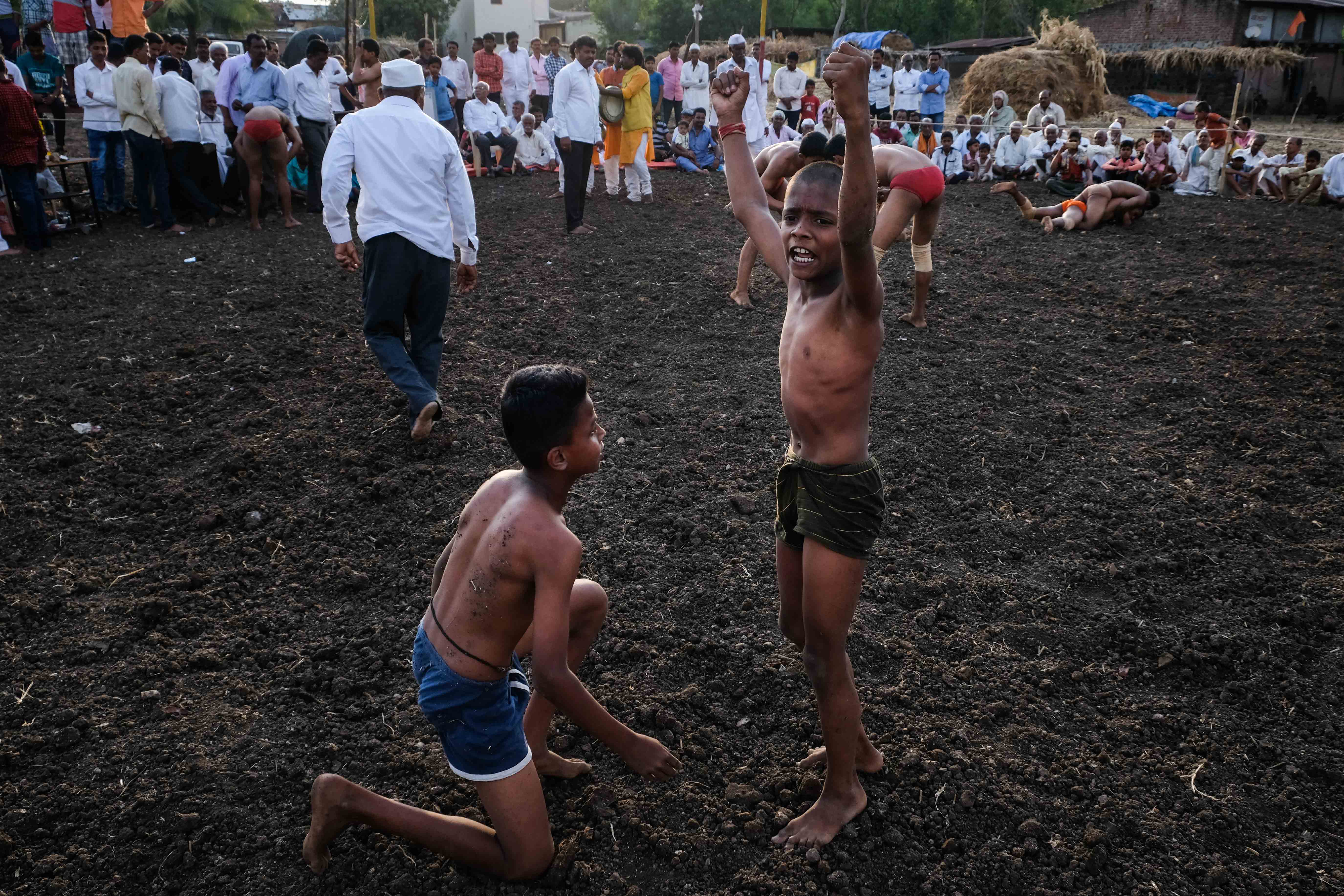 A rookie kid wrestler celebrating his victory at a local competition held in Savade village of Satara district in Maharashtra. Multiple matches are organised simultaneously in the open arena and running commentary and announcements are made over loudspeakers. Photograph by Indrajit Khambe ©Sahapedia