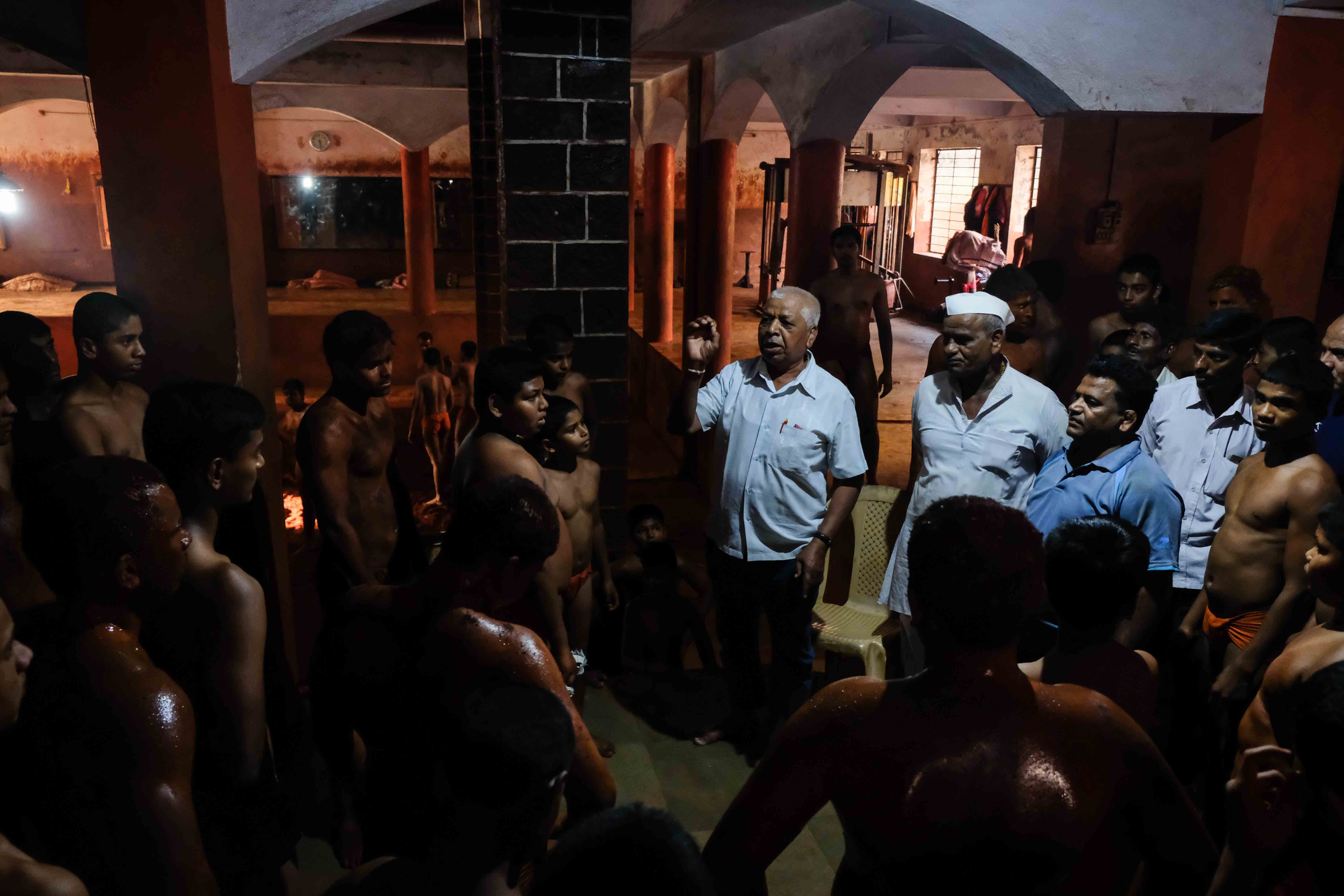 Senior referee Mr Bapusaheb Rade guiding young wrestlers at Motibag Akhara, Kolhapur. Aspiring pehelwans are guided by mentors, referees, coaches, senior wrestlers and trainers on the nuances of the sport. Passing down of knowledge through the guru-shishya parampara (teacher-student relationship) forms an integral part of the learning pedagogy at a taleem. Photograph by Indrajit Khambe ©Sahapedia