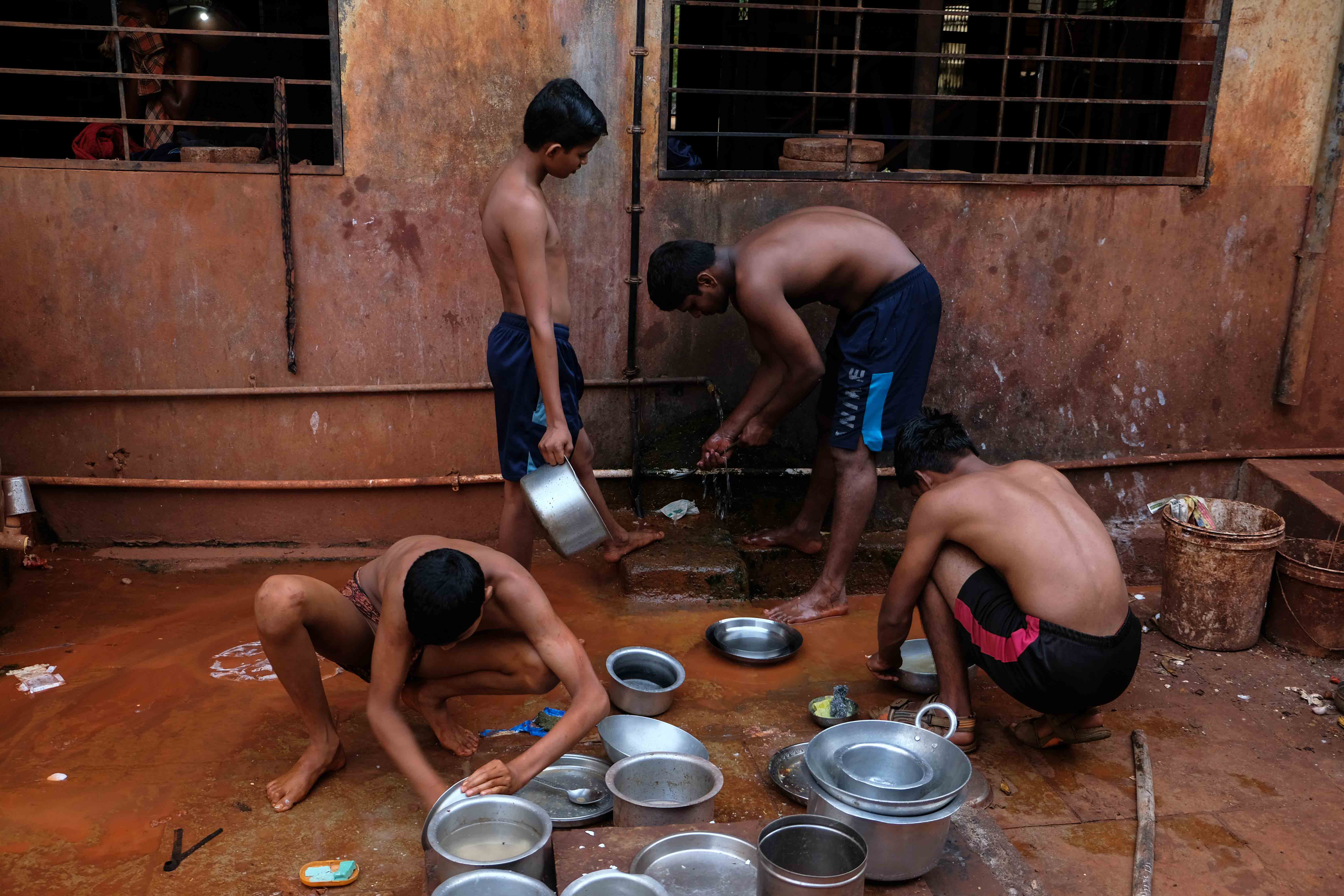  Young wrestlers washing pots in Motibag Akhara, Kolhapur. Every trainee wrestler is expected to complete their own chores and help each other out in maintaining cleanliness and discipline in the akhara. This involves helping in cleaning the place, preparing the arena, washing utensils, cooking food, and a range of other daily tasks. Photograph by Indrajit Khambe ©Sahapedia