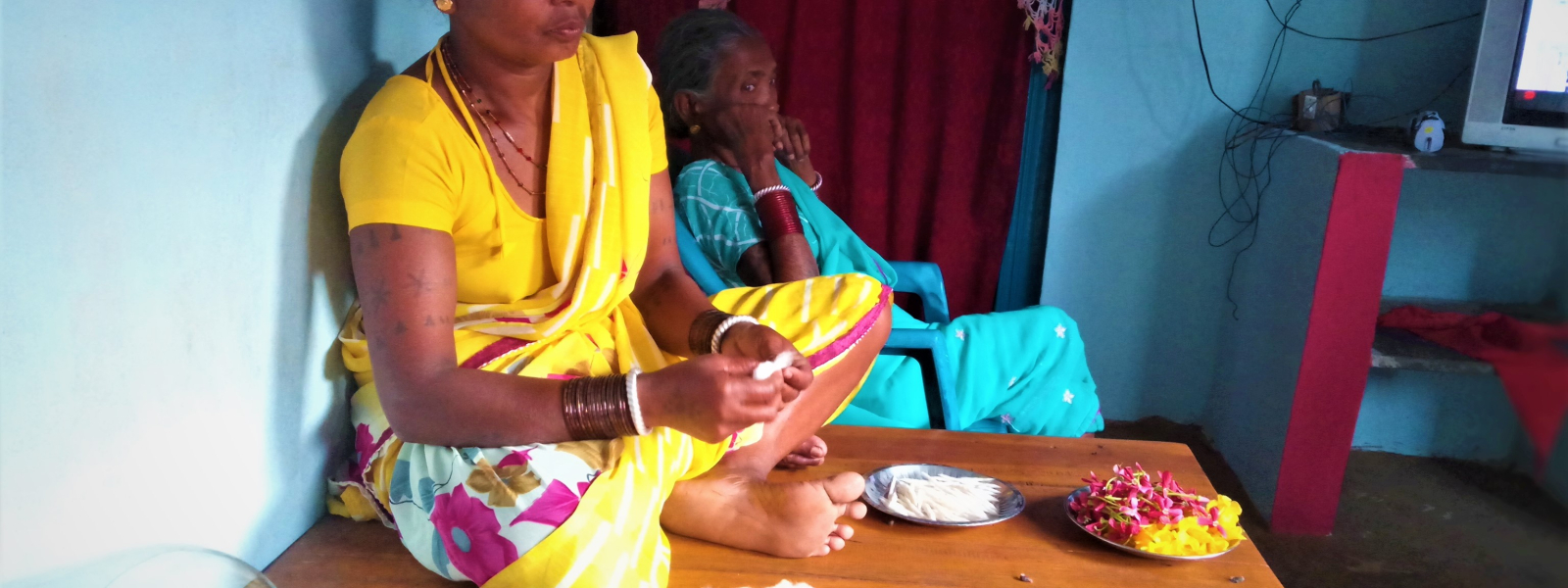 Women collect flowers and handcraft cotton wicks for small lamps in the afternoon.