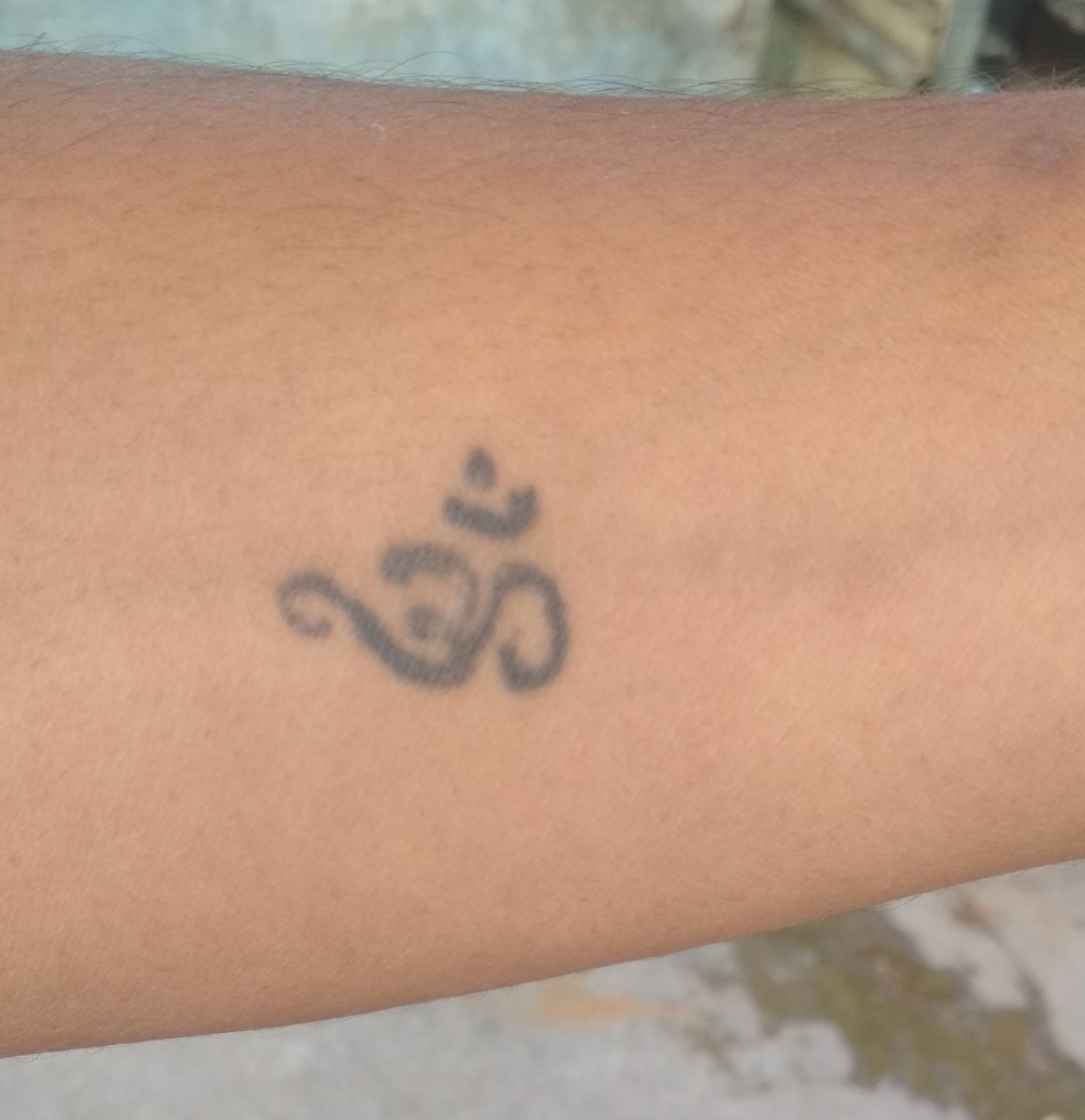 Om tattooed on forearm