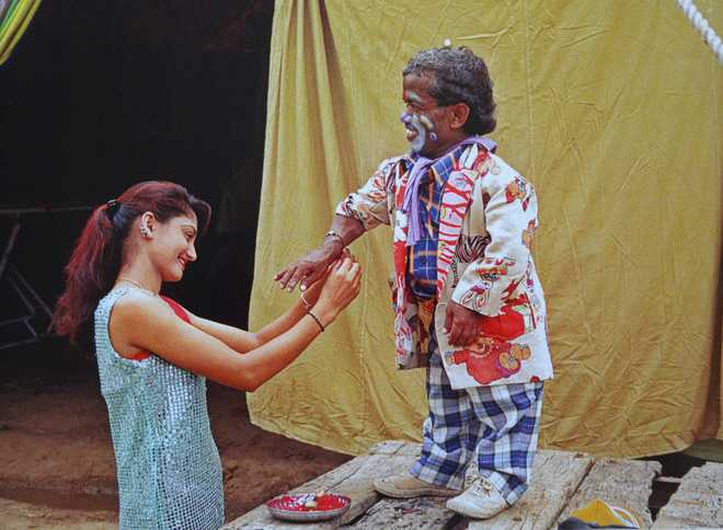 A woman tying a rakhi-thread to a clown. This photograph is part of Vivek Desai’s work called ‘Circus and Me’ (Courtesy: The Tribune)