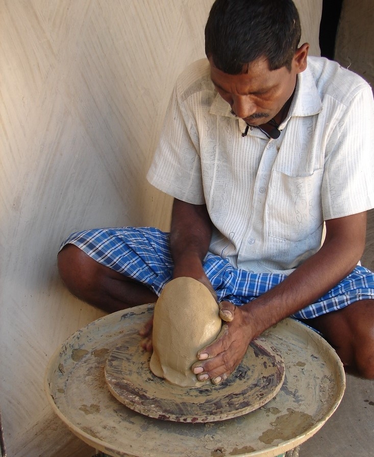 placing the lump of clay on the wheel