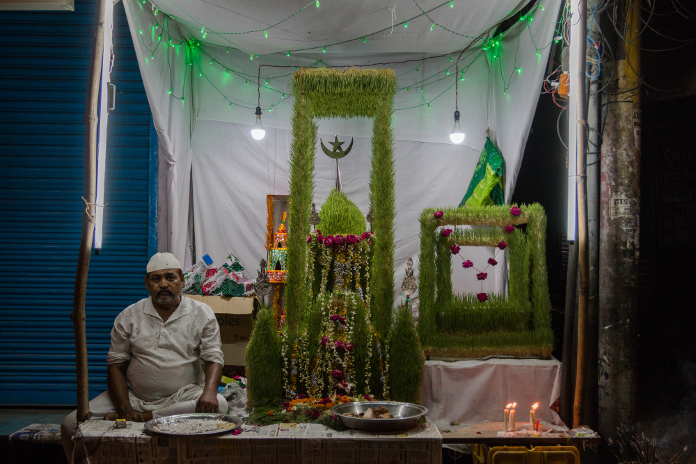 Fig. 11: A man sits with a jau ka taziya, installed on the roadside at Narhai in Lucknow