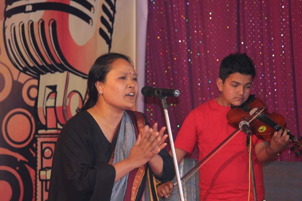 Fig. 3: Pavitra Lama performing as a participant in the first Dhamari organised by Nepali Sahitya Sansthan at Dr. I.B. Thapa N. Vidyalaya School, Pradhan Nagar, Siliguri on December 26, 2015 (Courtesy: Basu Thapa Pulani)