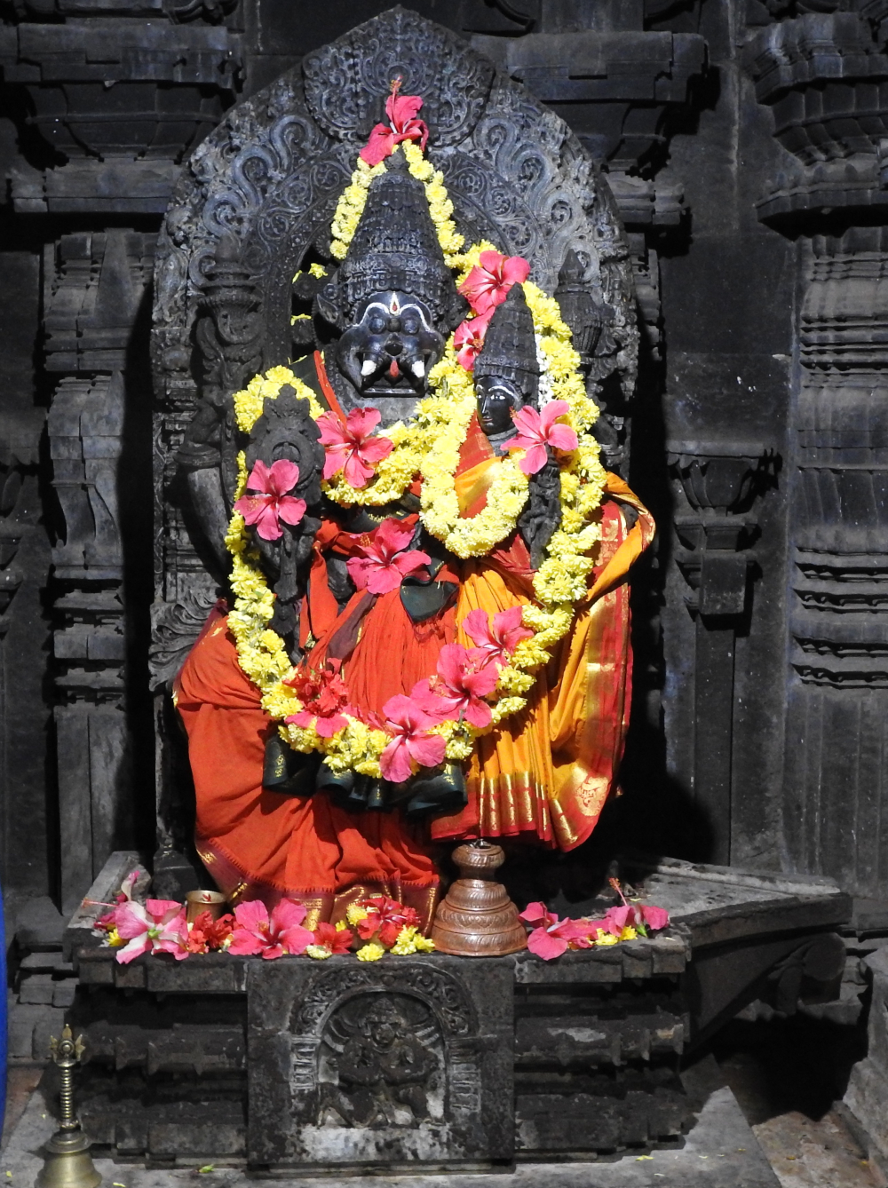 Fig. 2: The image of a seated Lakshmi-Narasimha from the left garbhagriha of the temple. The parikara (background wall surrounding the image) shows 10 principle incarnations of Vishnu starting from Matsya and ending with Kalki. Narasimha’s attributes include discus, lotus, mace and conch, Lakshmi holding lotus is perched on his left lap, and Garuda in anjalimudra (hand pose suggesting submission or prayer) is carved on the pedestal.