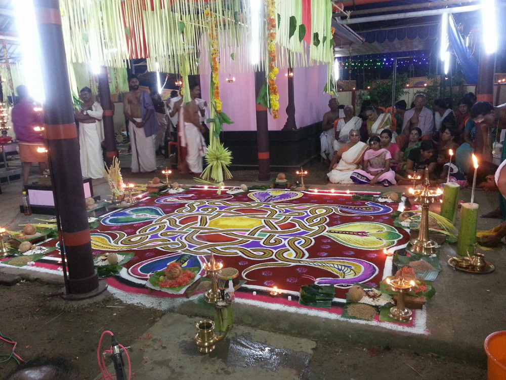 Fig. 3: The sarppakalam is decorated with flowers and coconut leaves; offerings like coconut, jaggery, banana, and rice are placed along the perimetre of the kalam; and brass lamps and incense sticks are lit to create an auspicious atmosphere (Courtesy: Gokul G) 