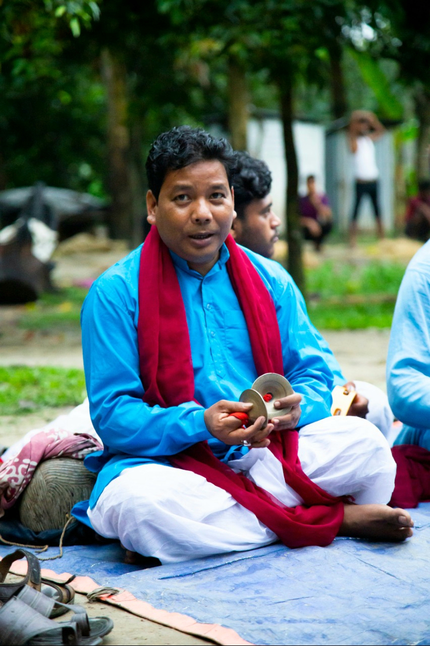 Fig. 7: Saral Sarkar playing his kartal (a percussion instrument) inside the dohar, the innermost circle of the performance space reserved for musicians. 