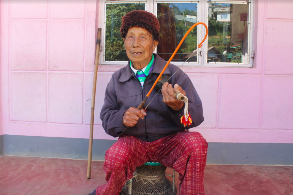 Fig. 1: An elder from Dailong village shows us the correct way to hold nrah. He was part of the khangchiu (men’s dormitory) in his youth and converted to Christianity in 1980. He is 98 years old and one of the oldest surviving Ruangmei elders in Tamenglong (Courtesy: Lungkiang Giang Pamei)