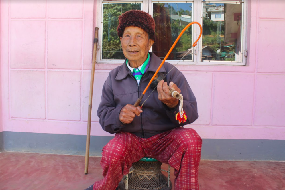 Fig. 1: An elder from Dailong village shows us the correct way to hold nrah. He was part of the khangchiu (men’s dormitory) in his youth and converted to Christianity in 1980. He is 98 years old and one of the oldest surviving Ruangmei elders in Tamenglong (Courtesy: Lungkiang Giang Pamei)